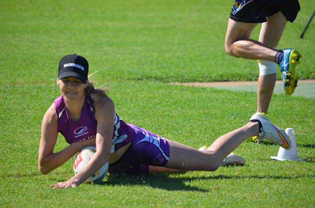 OVER: Mudgee mixed open winger Keira Rayner crosses for a touchdown.