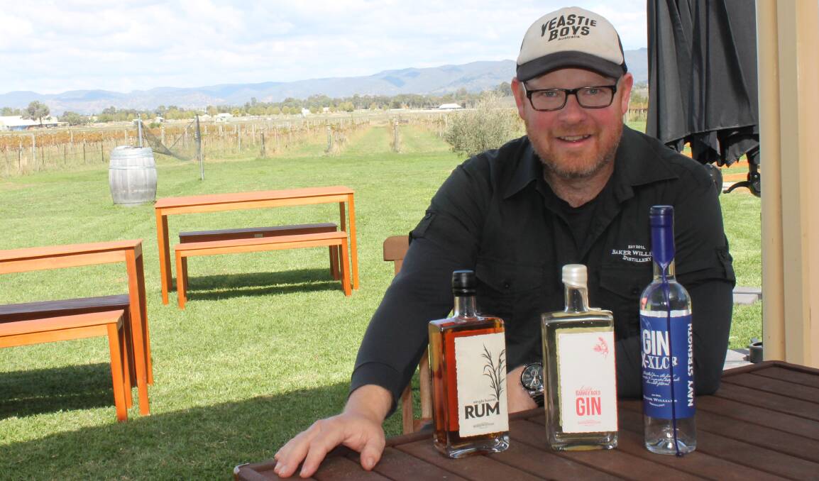 Baker Williams distiller Nathan Williams, with the medal winning spirits - Single Barrel Rum; Gin X-XLCR and the Whisky Barrel Aged Gin.