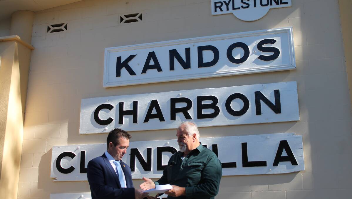 DOWN THE LINE: Kandos Museum president Buzz Sanderson presents member for Bathurst Paul Toole with a petition to re-open the rail line between Kandos and Rylstone for tourism purposes.