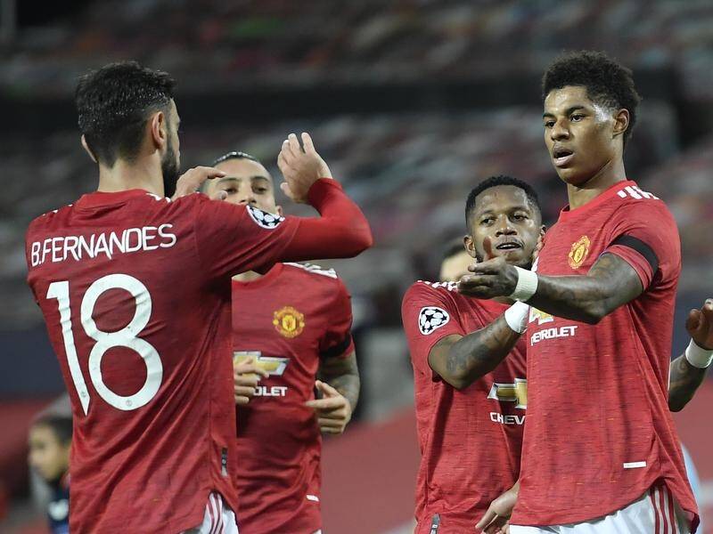 Marcus Rashford converts Manchester United's penalty and is congratulated by Bruno Fernandes.