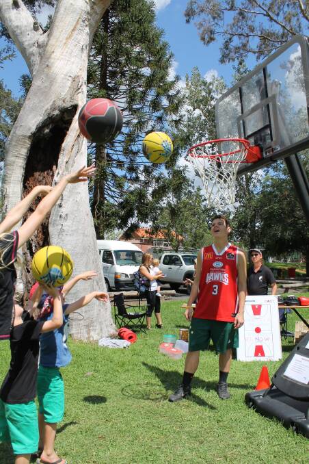 Local basketballer Jordan Woolmer lends a hand with some youngsters at the basketball stand.