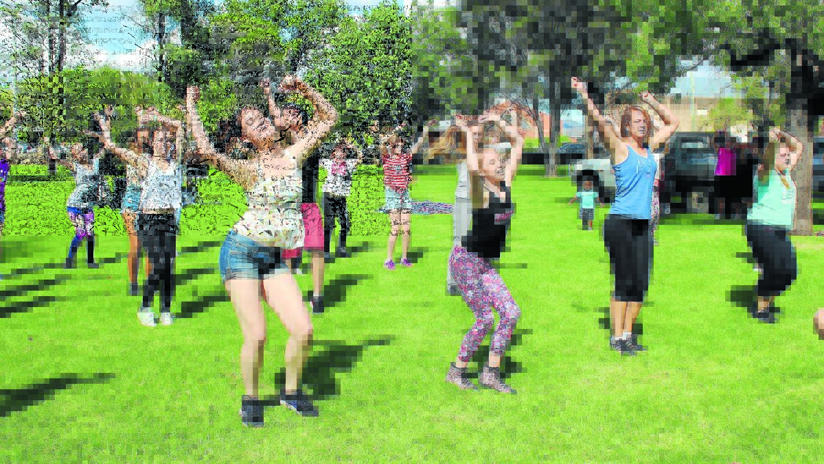 Dancers reach for the sky during the flash mob performance at Lawson Park on Saturday.