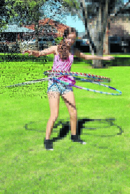 Allyssa Terrey juggles five hula hoops. 