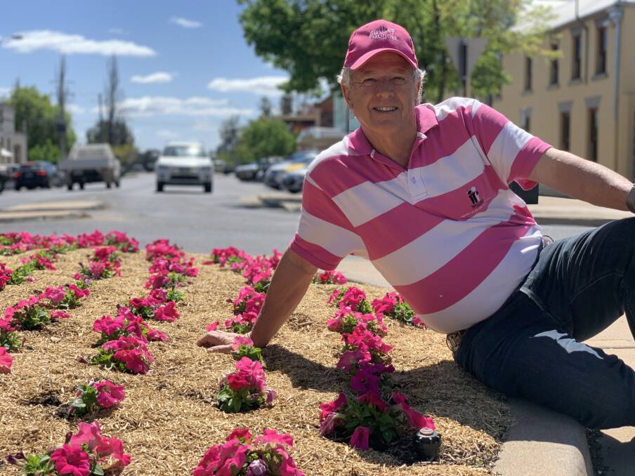 MATCH: Hugh Bateman, founder of Pink Up Mudgee among pink flowers at the clock, placed by Council in support of breast cancer awareness month. Photo: Benjamin Palmer