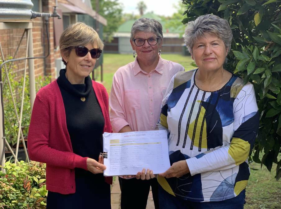 HOPE: Gulgong residents Kathryn Pearson, Kitty Eggerking and Sharelle Fellows holding the paper petition which has been signed thousands of times from residents and supporters of the call. Photo: Benjamin Palmer