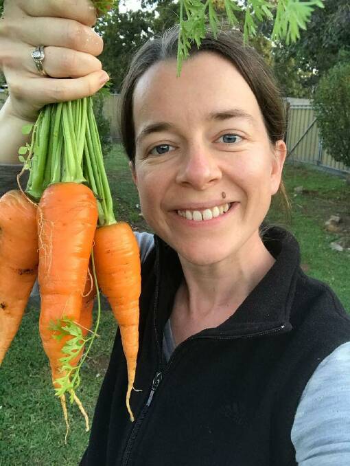 Veronika Barry with some homegrown carrots. Supplied