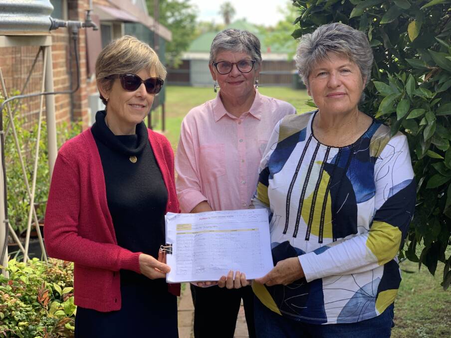 HOPE: Gulgong residents Kathryn Pearson, Kitty Eggerking and Sharelle Fellows holding the paper petition which has been signed more than 1600 times from residents and supporters of the call. Photo: Benjamin Palmer