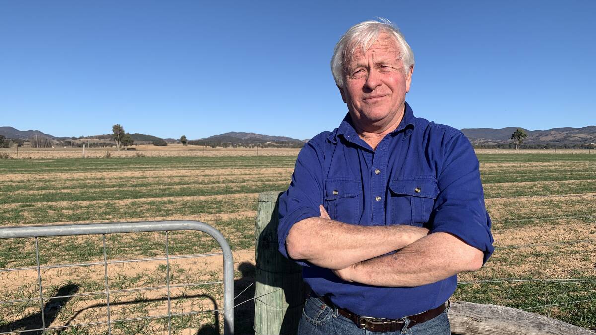Ted Cox standing at the gate, several hundred metres away from the proposed site of a solar farm. Photo: Benjamin Palmer