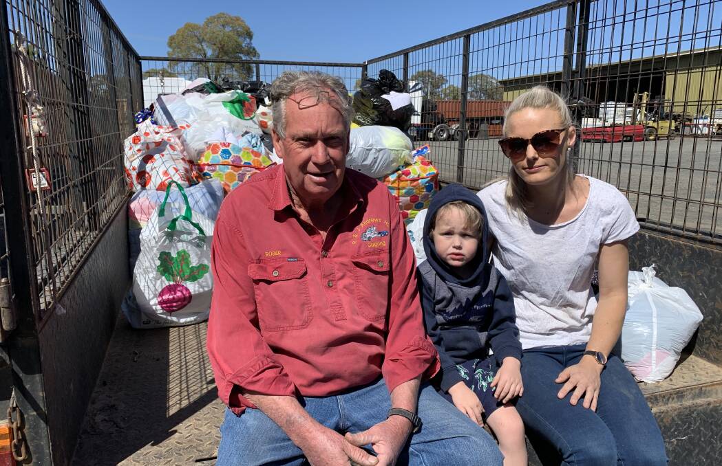 TEAMWORK: Roger Andrews and Lochie and Peta Ryan in Gulgong with a trailer full of donations ready to load into the container. Photo: Benjamin Palmer