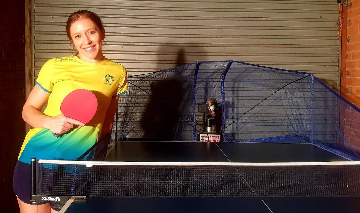 TRAINING: Michelle poses with her table tennis training robot. Supplied