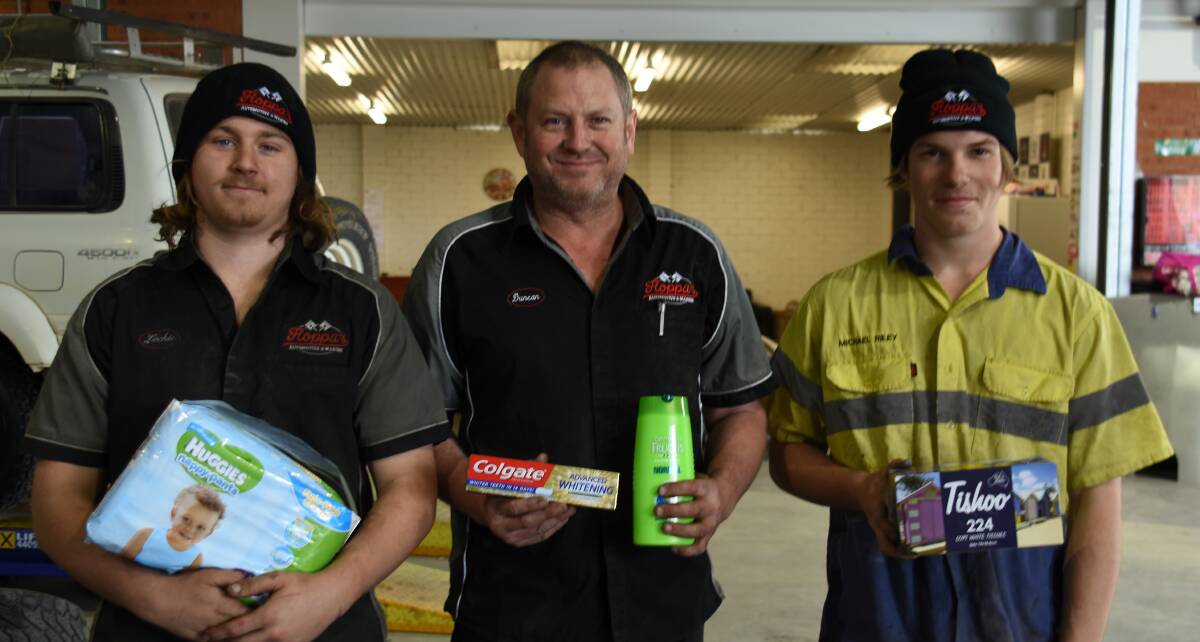 HELPING OUR FARMERS: Lochie Brown, Duncan Adam and Neihana Riley have taken stacks of toiletries donations thus far. Photo: Jake Humphreys