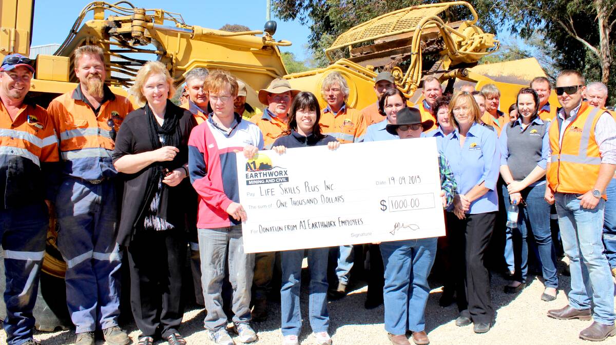 BONUS: Lifeskills Plus CEO Carolyn Peek accepts $1000 from A1 Earthworx yesterday. The local company has been fundraising from staff barbecues. PHOTO: DARREN SNYDER